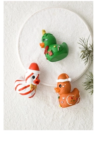 Detailed view of three festive resin ducks featuring Christmas tree and gingerbread themes