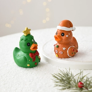 Christmas tree and gingerbread resin duck figurines with warm festive bokeh background