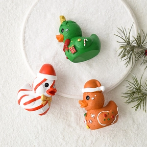 Three creative Christmas resin duck figurines including gingerbread and tree themes on snow