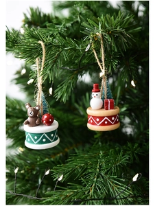 Close-up of resin Christmas ornaments featuring a snowman and bear on a holiday tree