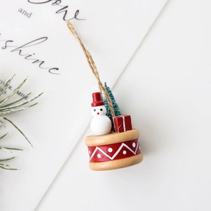 Miniature Christmas resin ornament featuring a snowman, pine tree and gift on a red drum