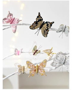 Detailed view of artificial butterflies with sequins and pearls on white branches