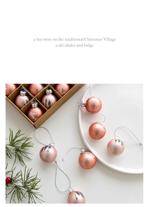 Macro detail of rose gold Christmas ornaments with Merry and Bright script in a gift box