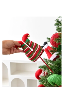 Detailed plush Christmas elf leg picks with festive ornaments and gold bells for tree decor