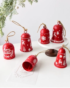 Detail of red Christmas metal bells with white reindeer and snowflake motifs and jute rope
