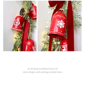 Detail of red Christmas bell with snowflake patterns and silk ribbon on pine branches