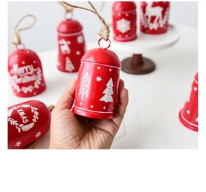 Macro shot of red metal Christmas bells with white reindeer and snowflake motifs