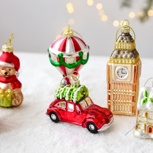 Set of Christmas glass ornaments featuring red truck and bell tower on snow background