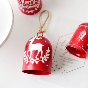 Red metal Christmas bell with white reindeer motif and jute rope hanging loop