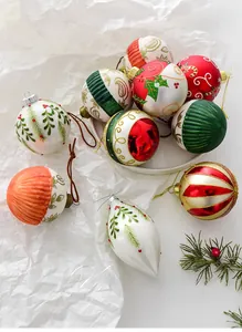 Detail view of assorted red and green glass Christmas ornaments with hand-painted patterns