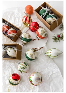 Detail of hand-painted Christmas tree ornaments with festive red, green and gold patterns