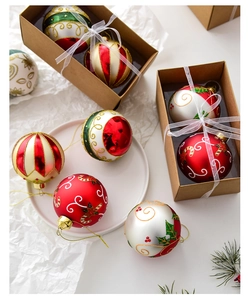 Detail view of hand-painted Christmas glass baubles with festive patterns in a gift box