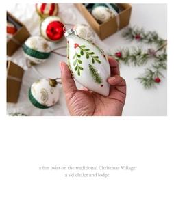 Detail of hand-painted glass ornaments with pine needles and red berry motifs