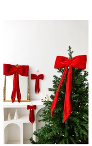 Fiocchi natalizi in velluto rosso di varie misure su albero di Natale e specchio