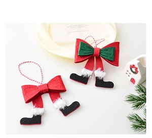 Detail of red and green felt Christmas bow ornaments with Santa boots and hanging rope