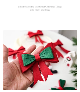 Detail view of a red and green felt Christmas bow ornament held in hand for scale