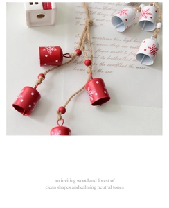Detail of red and white metal bells with snowflake patterns on rustic hemp rope