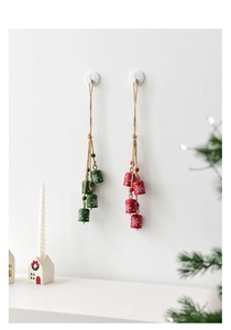 Close-up of metal Christmas bells with white snowflakes on red and green ropes