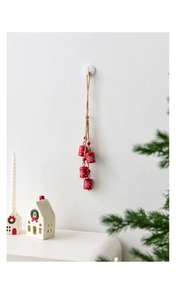 Close-up of red metal Christmas bells with white snowflakes on jute rope with red wood beads
