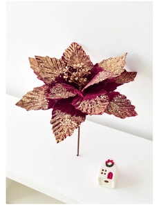 Détail de fleur de poinsettia en velours bordeaux avec bords dorés pour décoration de Noël