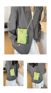 Detail of light green crossbody mini bag featuring a pearl button and silk tassel charm