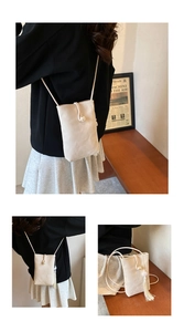 Detailed view of cream white phone bag with decorative pearl buckle and long tassels