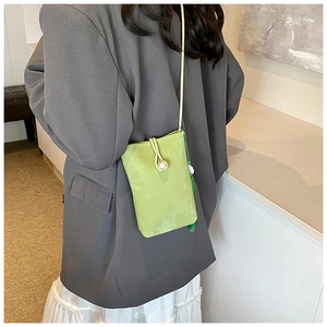 Detail of light green mini crossbody phone bag with pearl buckle and matching tassel