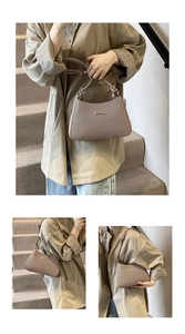 Detail of minimalist underarm bag featuring a knotted handle and gold metal bar accent