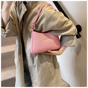 Detail view of pink woven shoulder bag with thick knotted rope strap and gold hardware