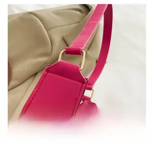 Close-up of vibrant rose red leather bag showing gold buckle and neat stitching details