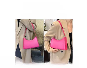 Detailed view of rose pink baguette underarm bag with smooth leather and silver hardware