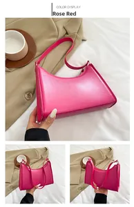 Detail view of the rose red underarm bag with a minimalist half-moon leather structure