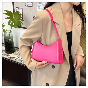 Fuchsia synthetic leather hobo bag styled on a shoulder with minimalist casual aesthetic