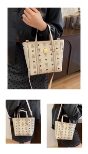 Détail du sac seau beige avec imprimé ours, plaque dorée et poignées dans un intérieur