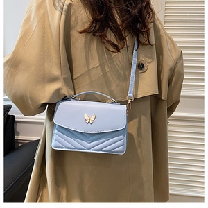 Light blue crossbody bag with gold butterfly clasp and V-quilted texture detail