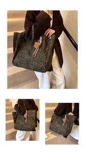 Detail of leopard print tote bag featuring a plush bear pendant and striped ribbon accent