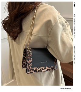 Detail of leopard print contrast shoulder bag with gold chain strap on a model