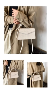 Detailed view of cream textured crossbody bag with woven handle and diamond pattern