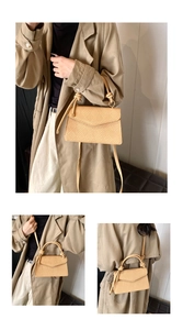 Detailed view of beige woven textured crossbody bag with knotted handle and strap