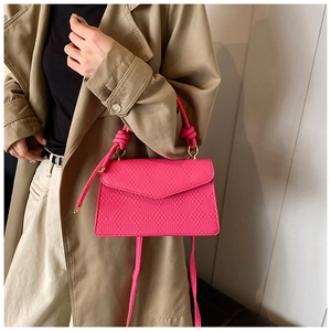 Borsa trapuntata rosa acceso con manico ad anello abbinata a un trench beige di classe
