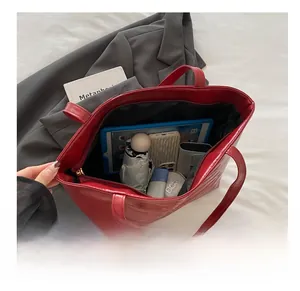 Top view of large red faux leather tote bag showing spacious interior with essentials