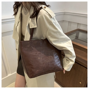 Detail of dark brown tote bag featuring unique 3D rib embossed texture and slim straps