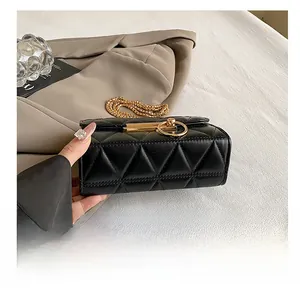 Detail of the black quilted mini bag showing the gold buckle and polished wear-resistant base