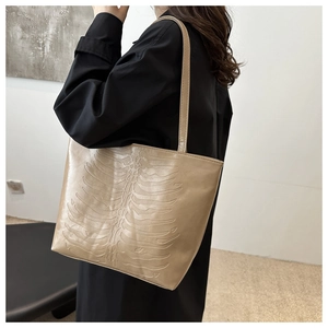 Detail of light beige tote bag with unique 3D embossed rib cage pattern on PU leather