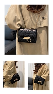 Close-up of black quilted mini bag featuring a gold rectangular clasp and chain strap