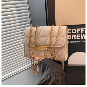 Detail of cream quilted crossbody bag with golden chain and triangle texture