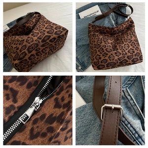 Close-up of leopard print tote bag with silver zipper and brown leather strap detail