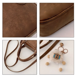 Detail view of vintage brown bag with lucky OHIO embossing and plush sheep pendant