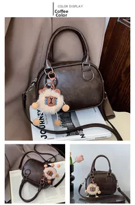 Detail of dark brown vintage bowling bag with embossed letters and plush charm