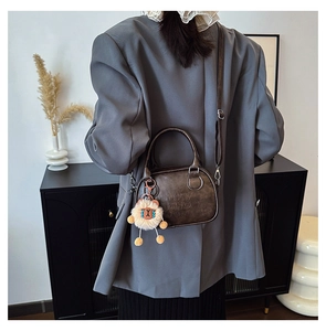 Détail d'un sac à main en cuir marron vintage avec gaufrage LUCKY et lion en peluche